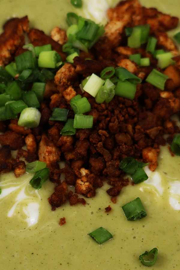 Zbliżenie na zupę z dodatkiem kruszonej posypki i szczypiorku.